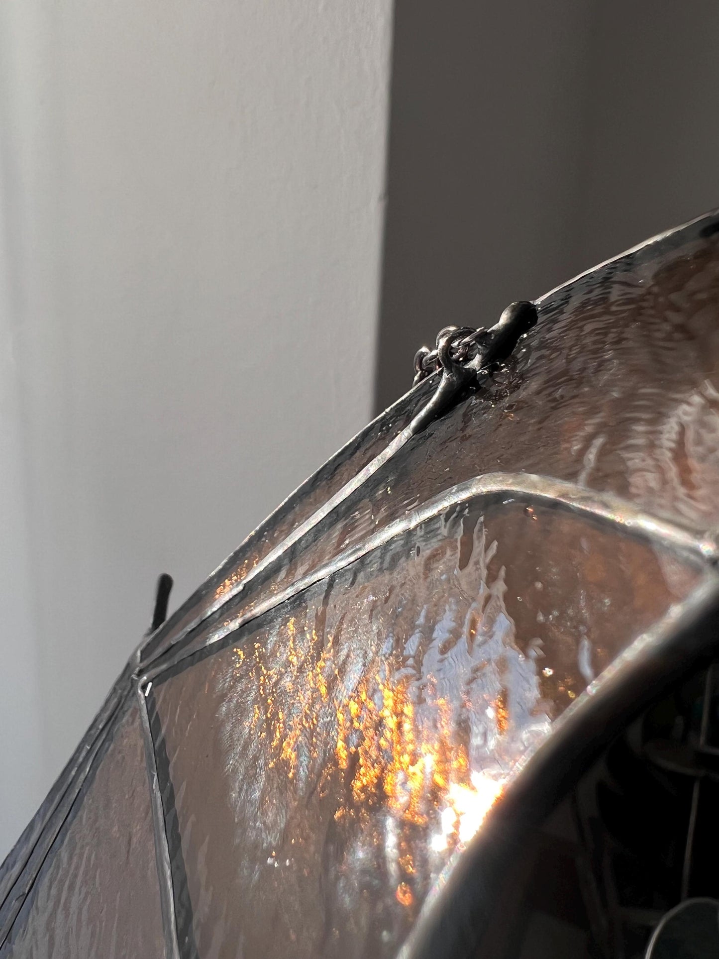 stained glass decoration in the form of a bat in amber and brown tones, the wing is depicted in close-up, revealing small handmade details