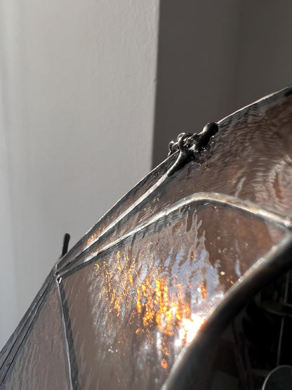 stained glass decoration in the form of a bat in amber and brown tones, the wing is depicted in close-up, revealing small handmade details