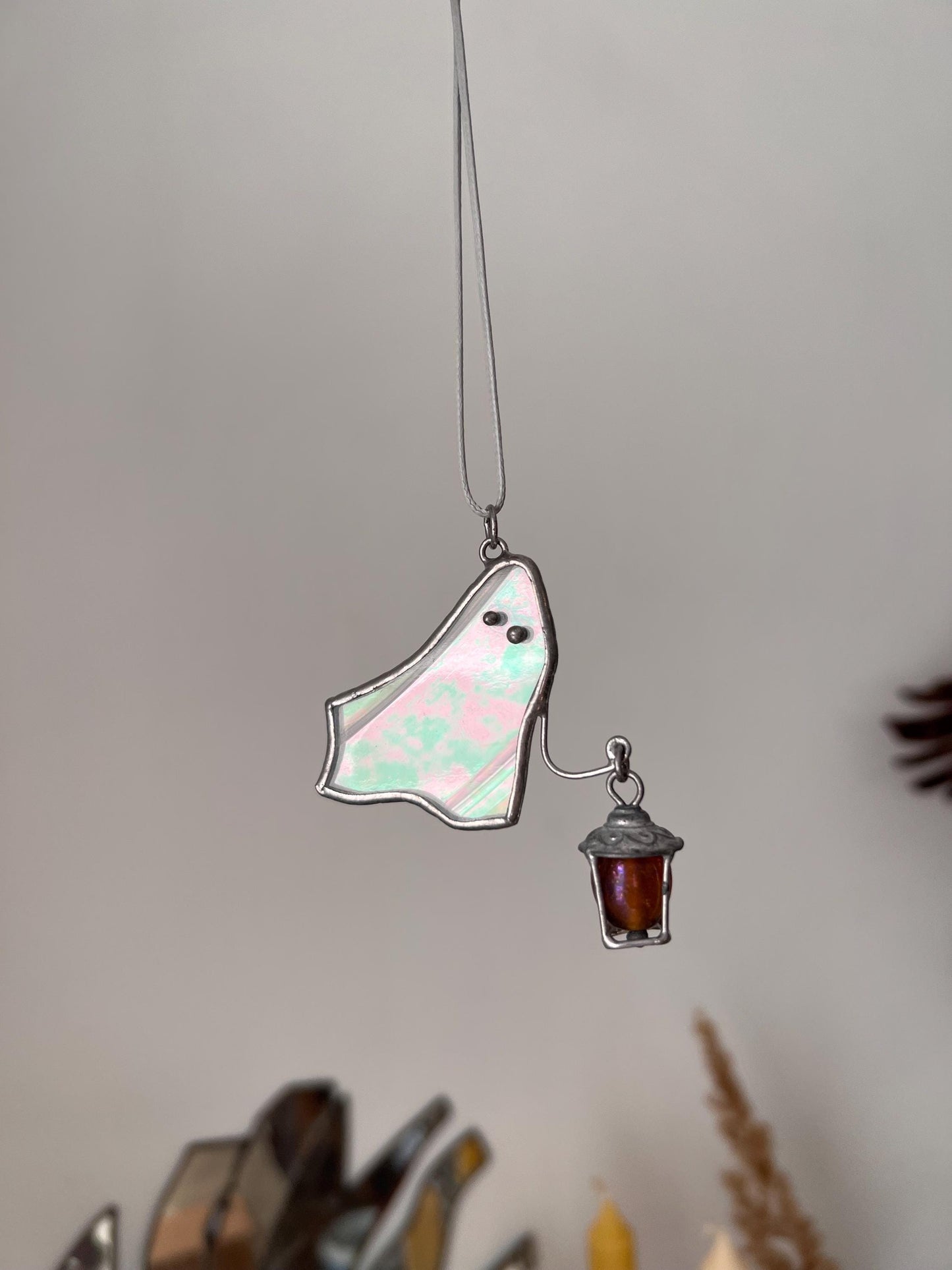 Stained glass ghost suncatcher pendant glowing in the light with magical reflections