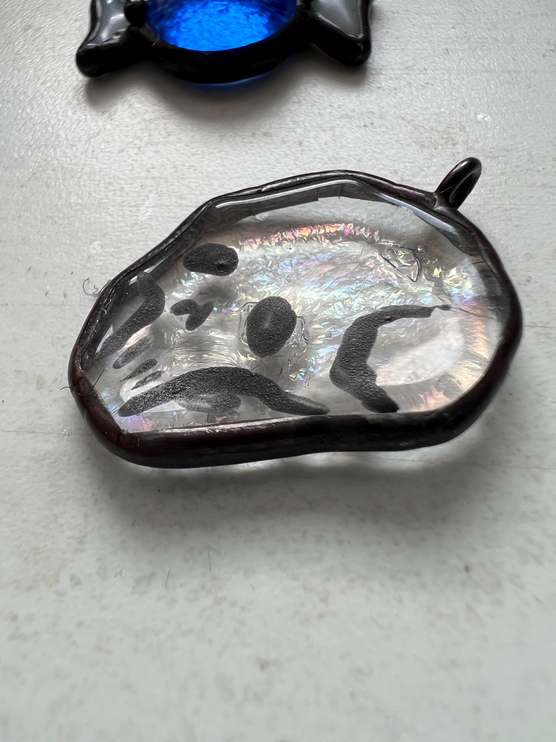 Close-up of transparent stained glass skull earring