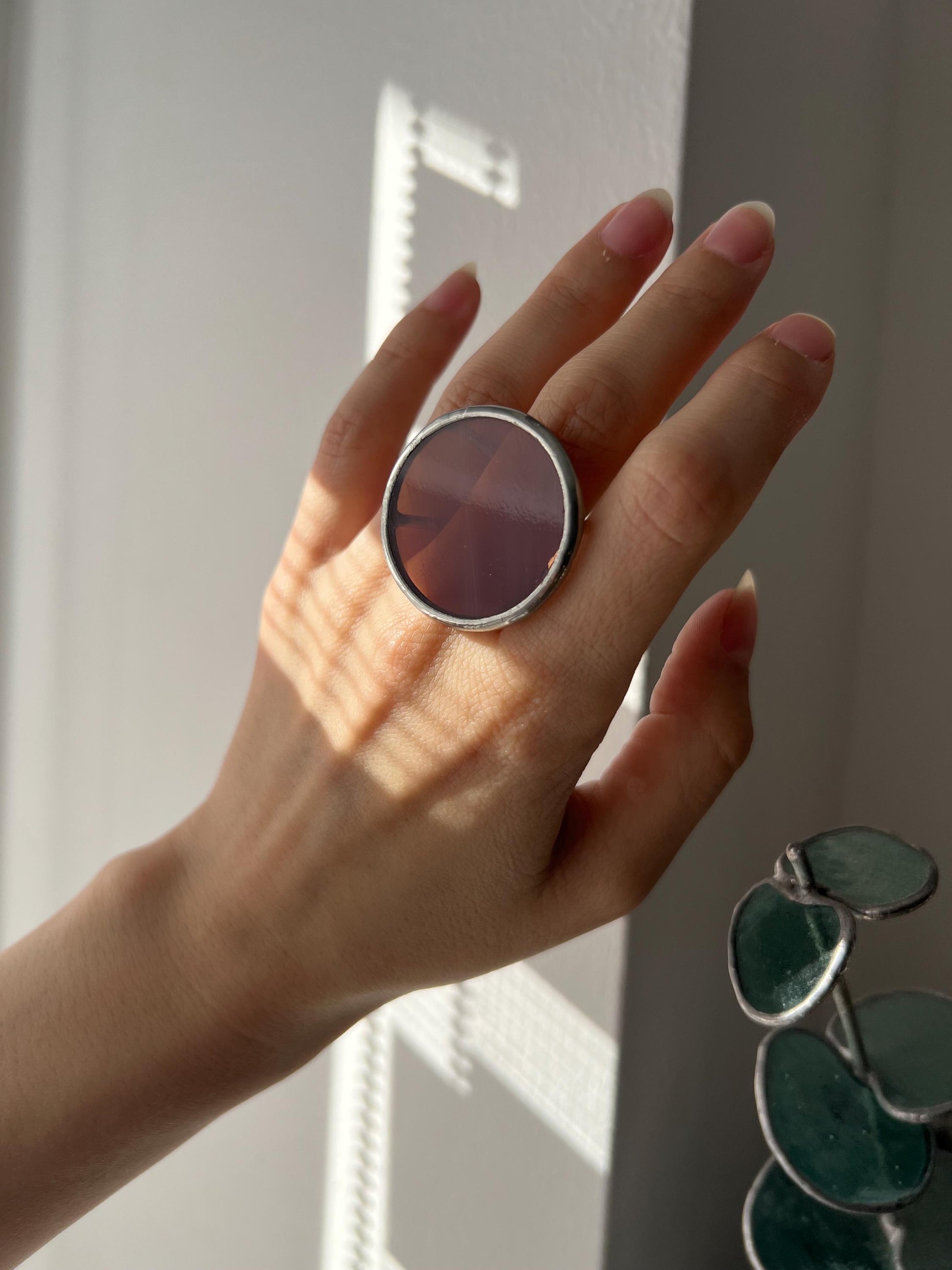 Stained glass statement ring on hand near window