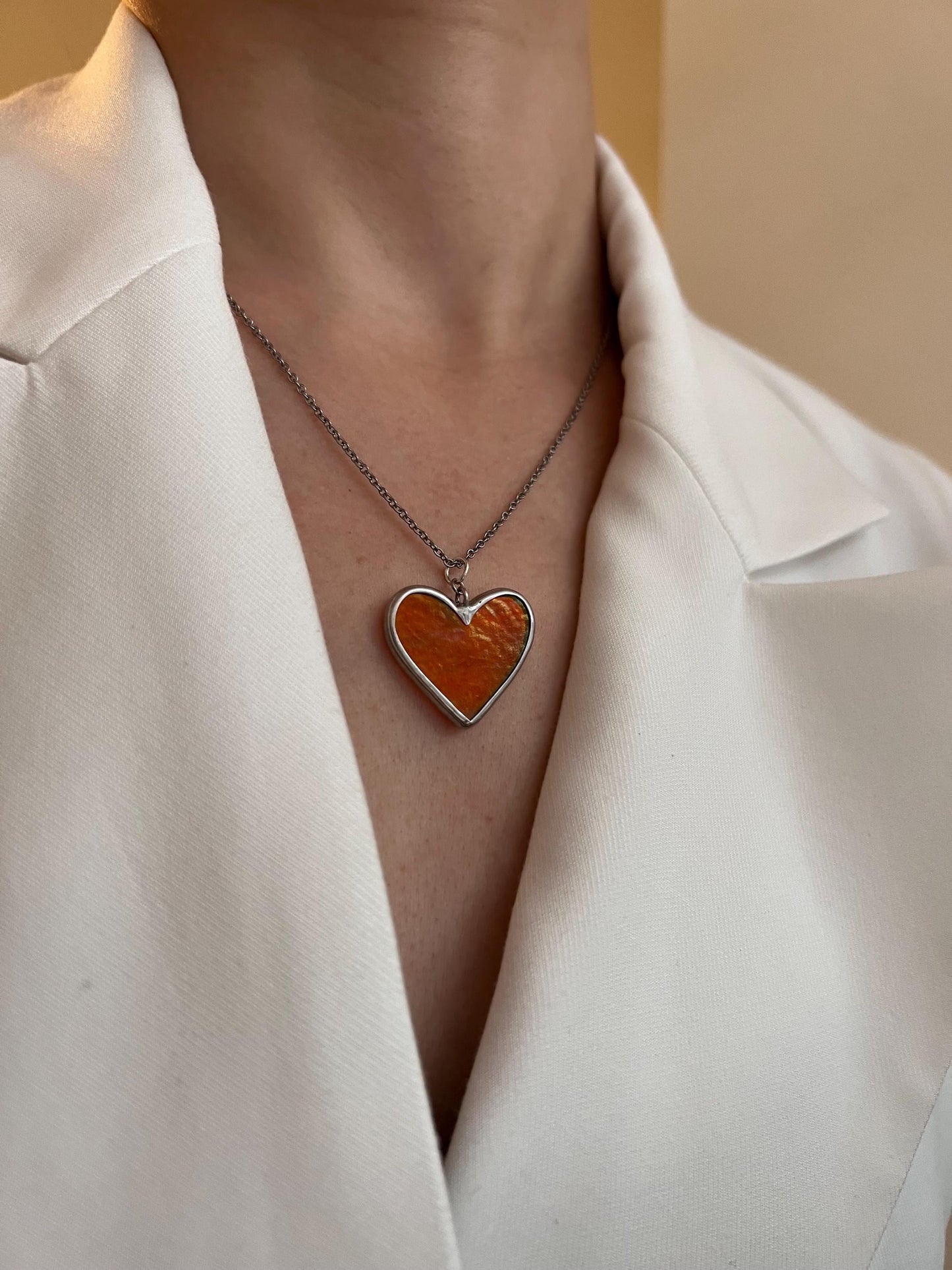 Close-up of a bright red heart on a thin chain.