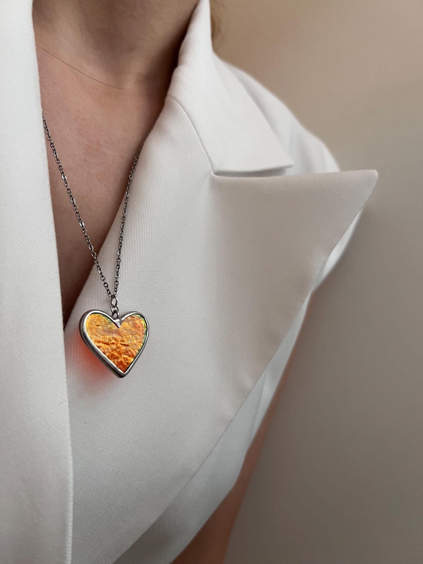 Heart pendant on the neck, focused photo with glass sparkle.