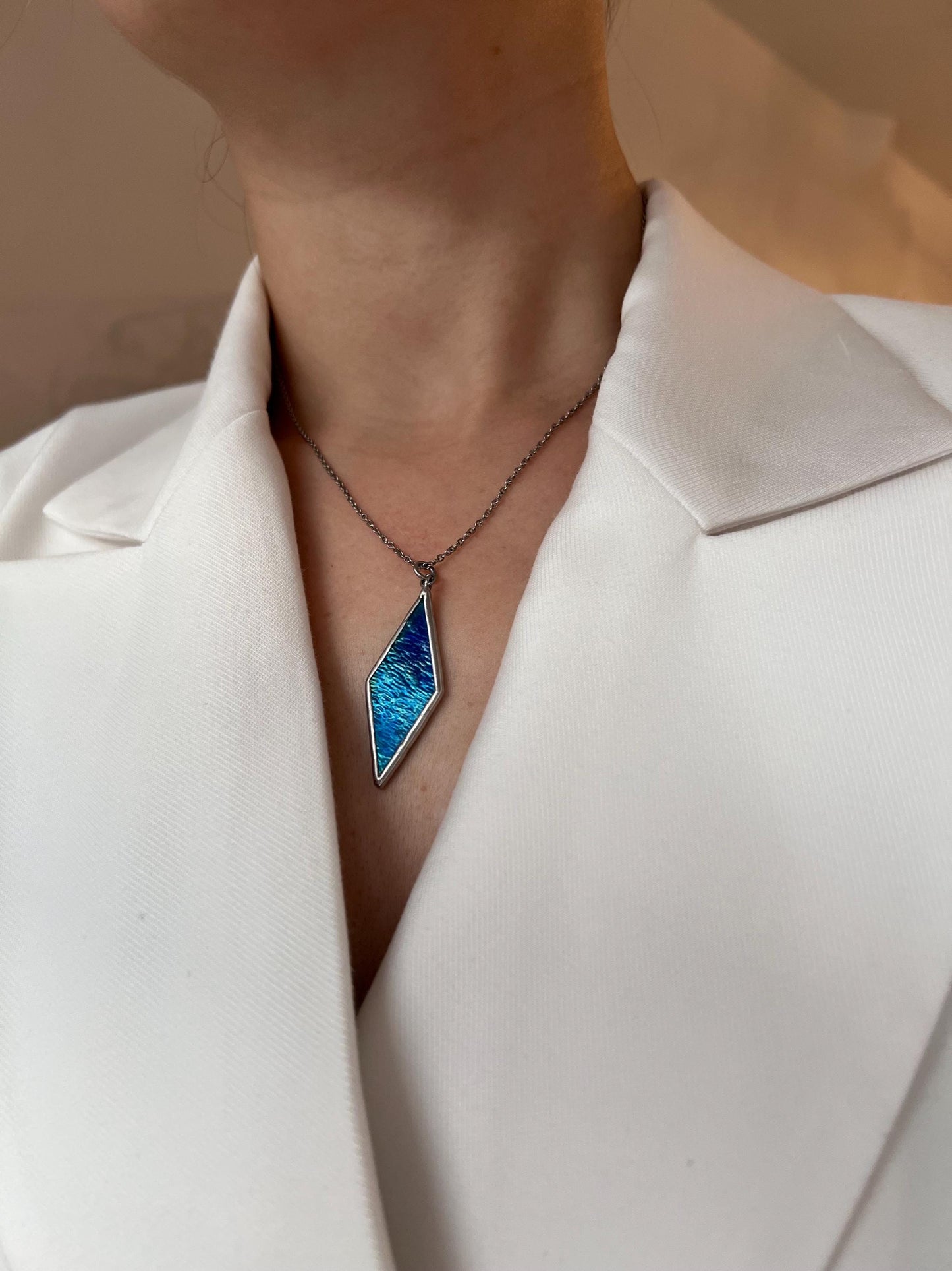 Stylish women's pendant made of blue glass in a diamond shape.