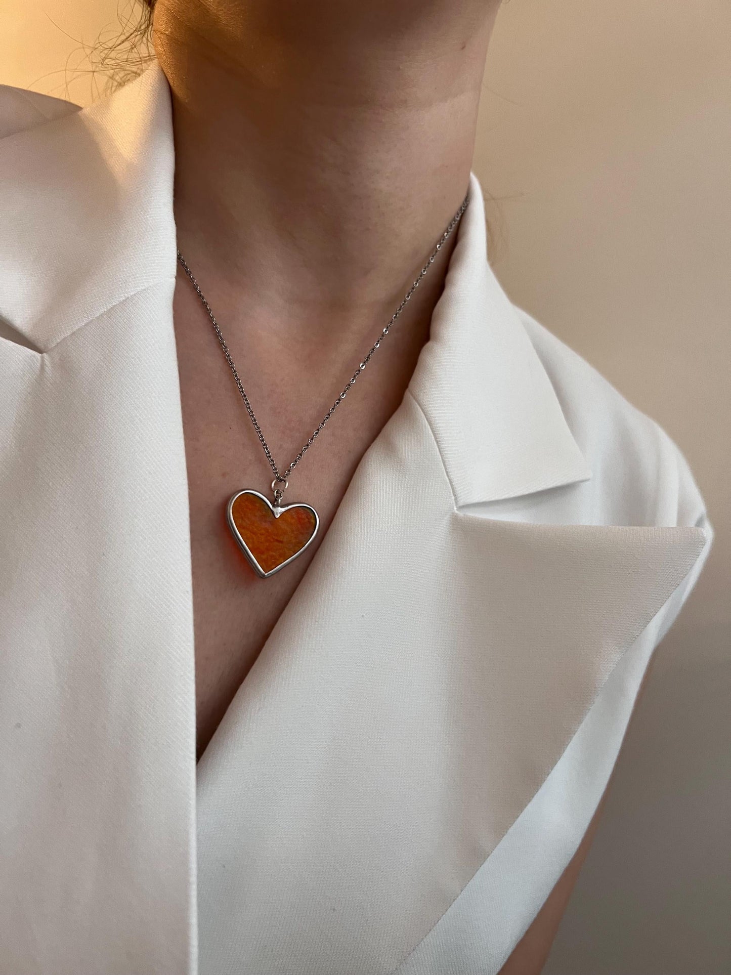 Stained glass heart on the neck, close-up photo from the side.
