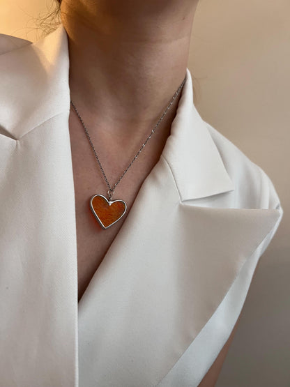 Stained glass heart on the neck, close-up photo from the side.