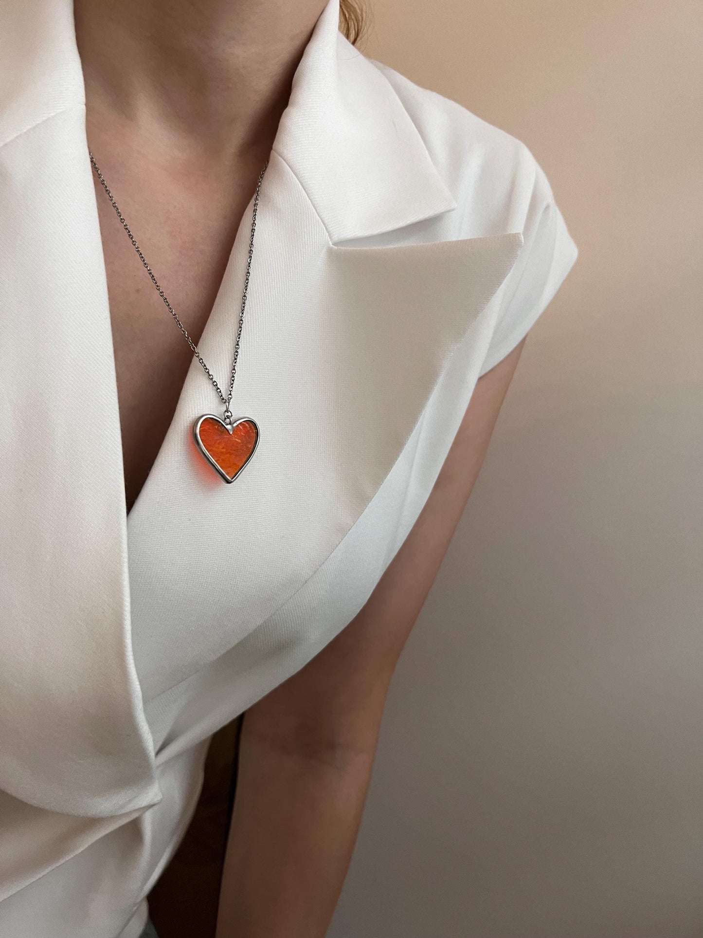 Heart pendant on the chest in a minimalistic image.