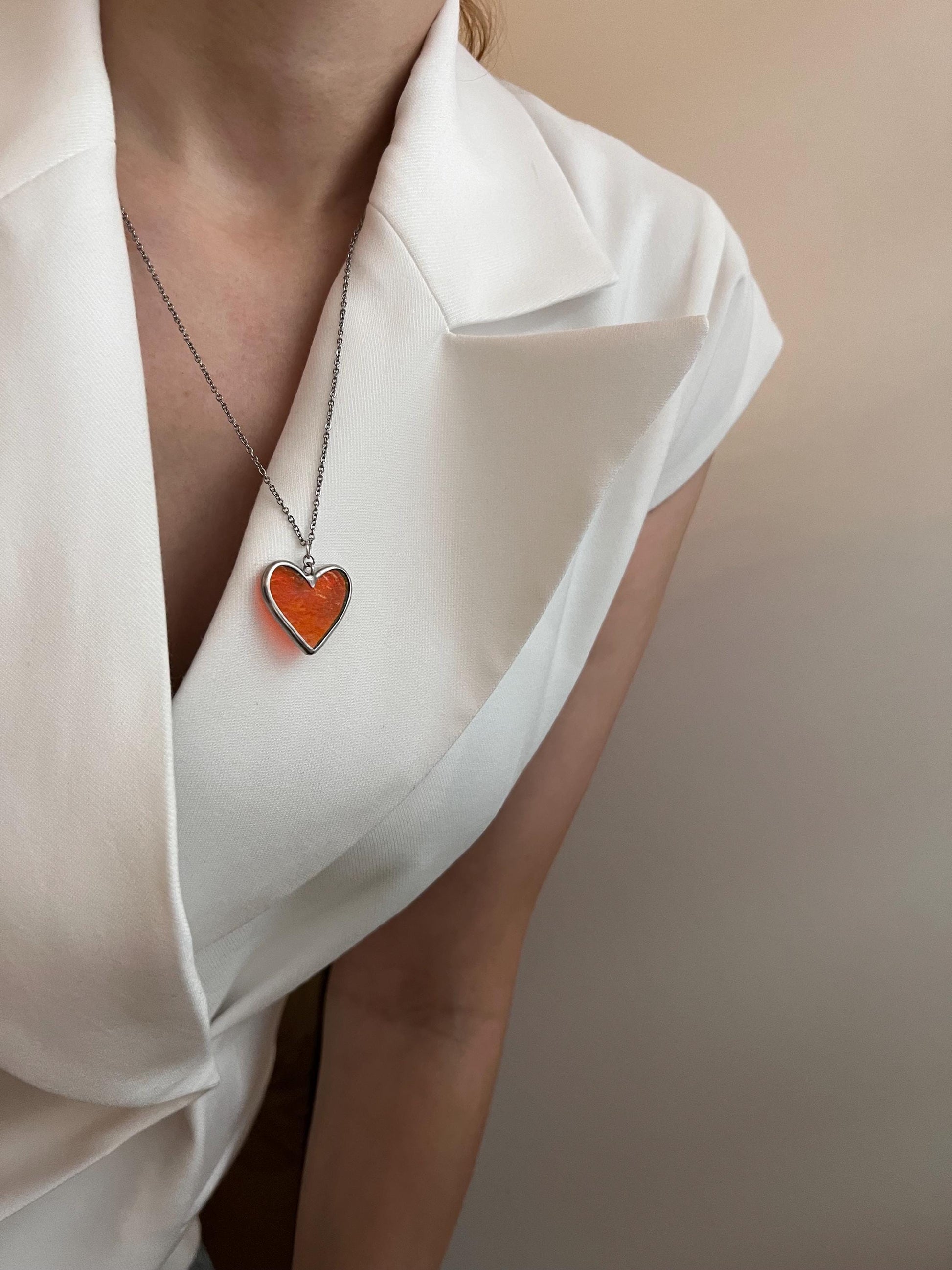 Heart pendant on the chest in a minimalistic image.