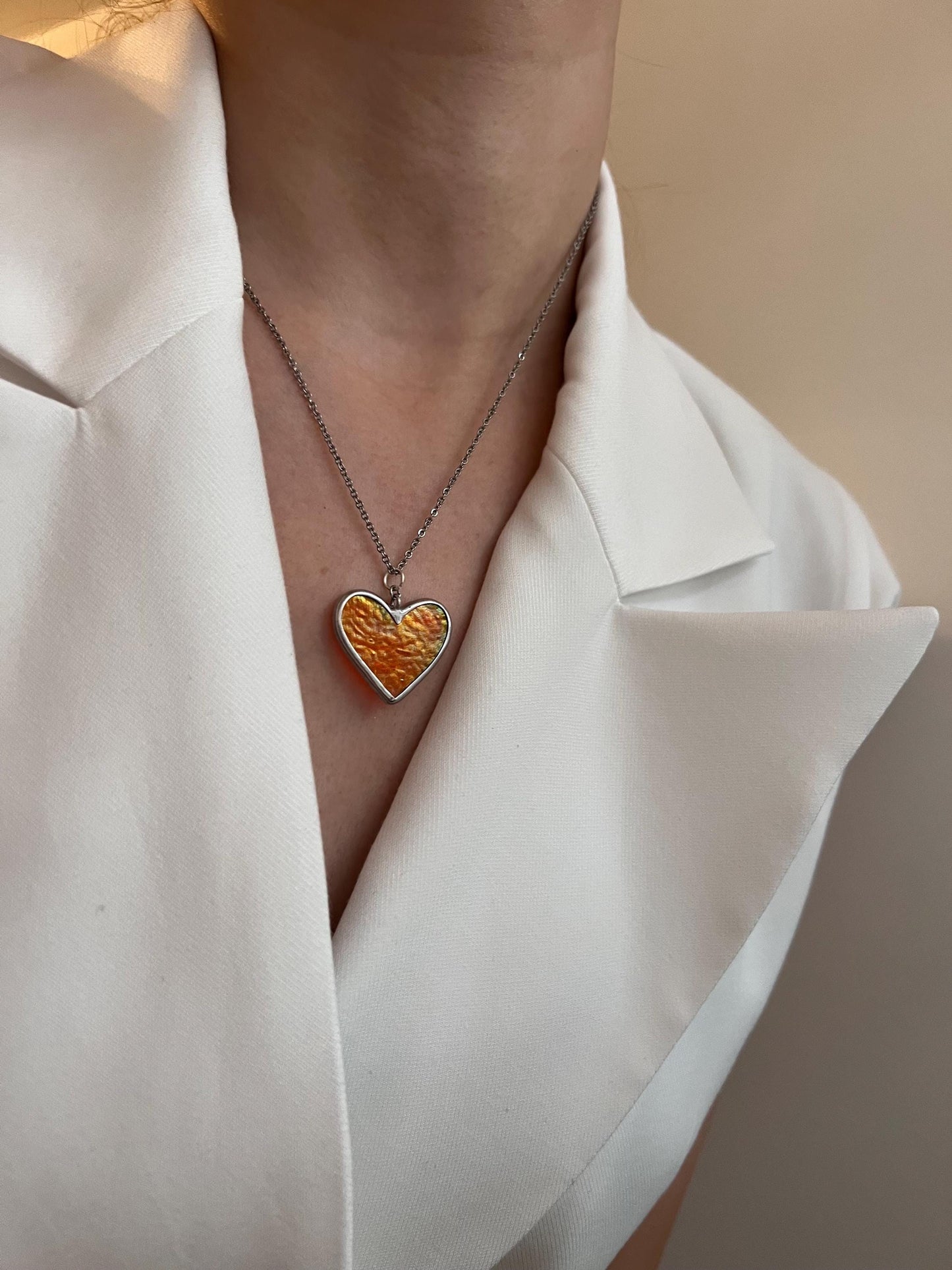Iridescent heart pendant in shimmering light.