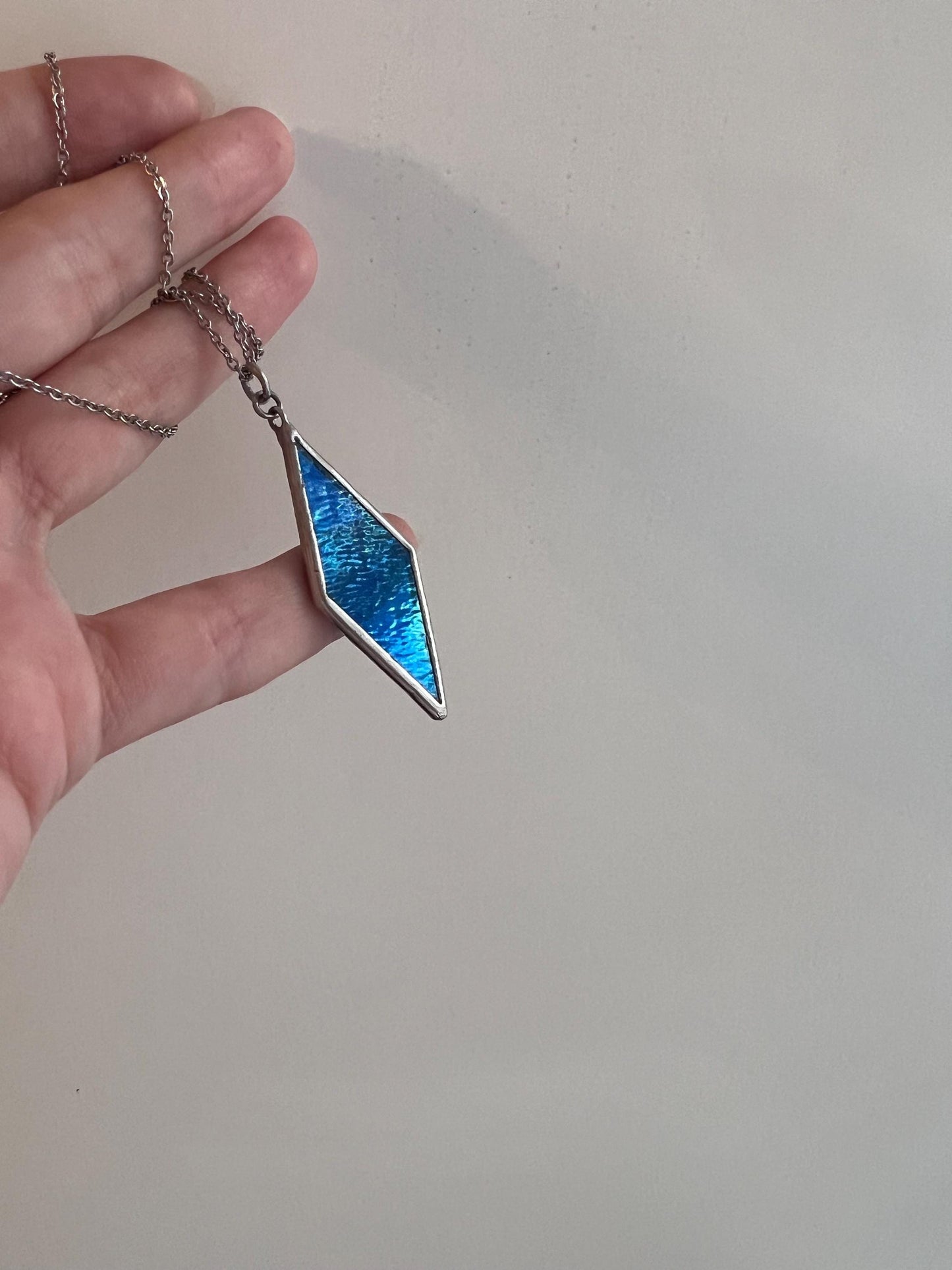 Blue stained glass pendant, side view, demonstrating the play of light.