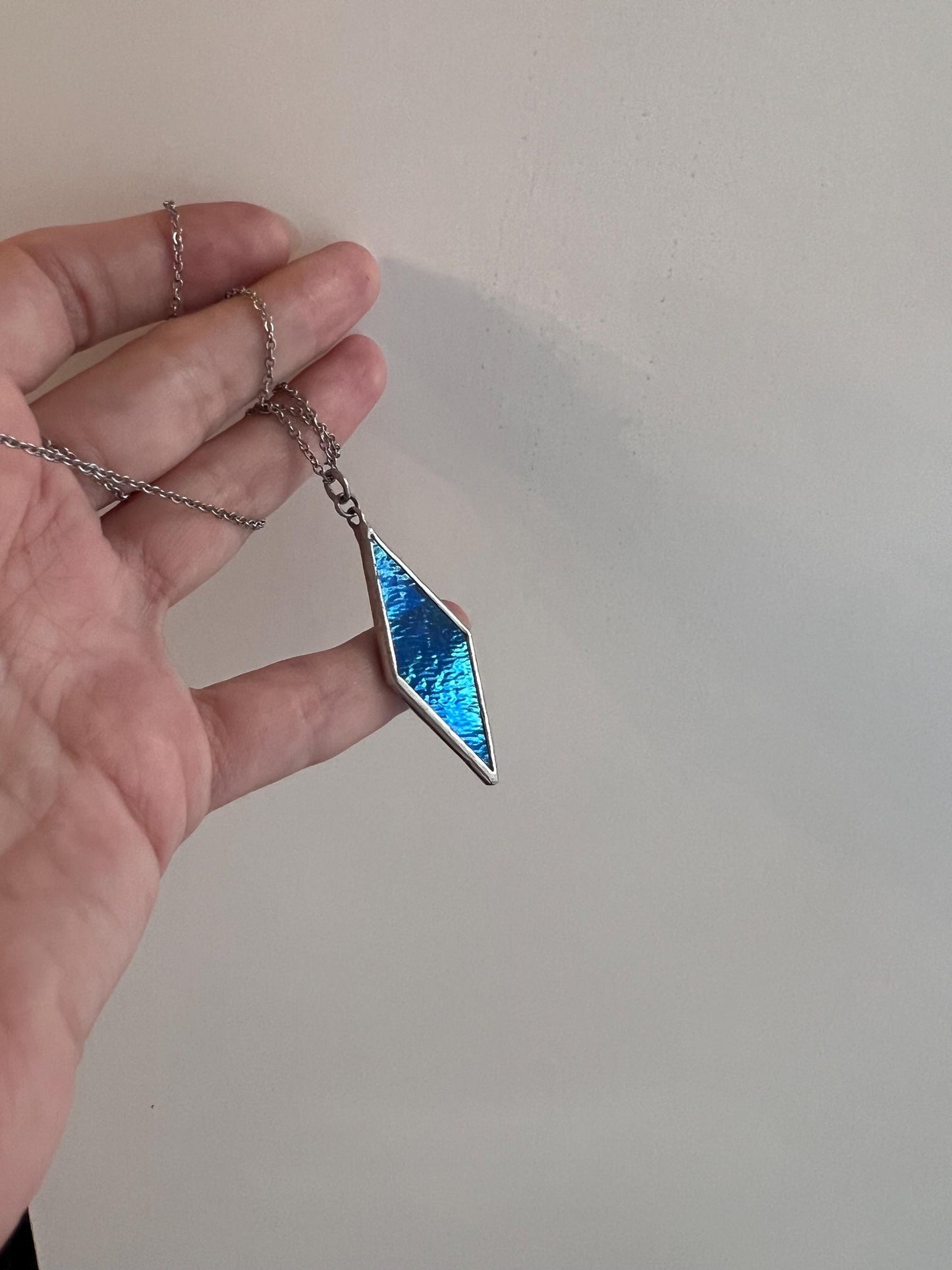 Geometric diamond pendant on the palm of your hand - an elegant handmade decoration.