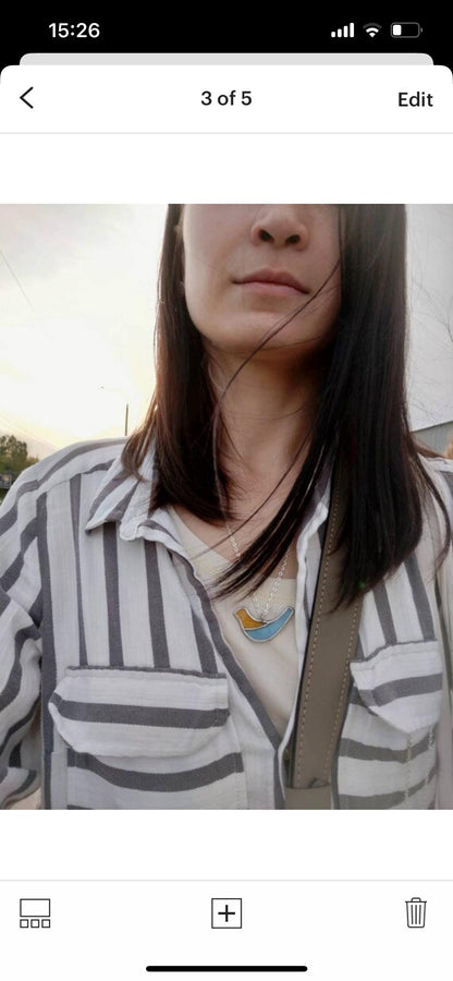 Elegant stained glass bird pendant worn on model