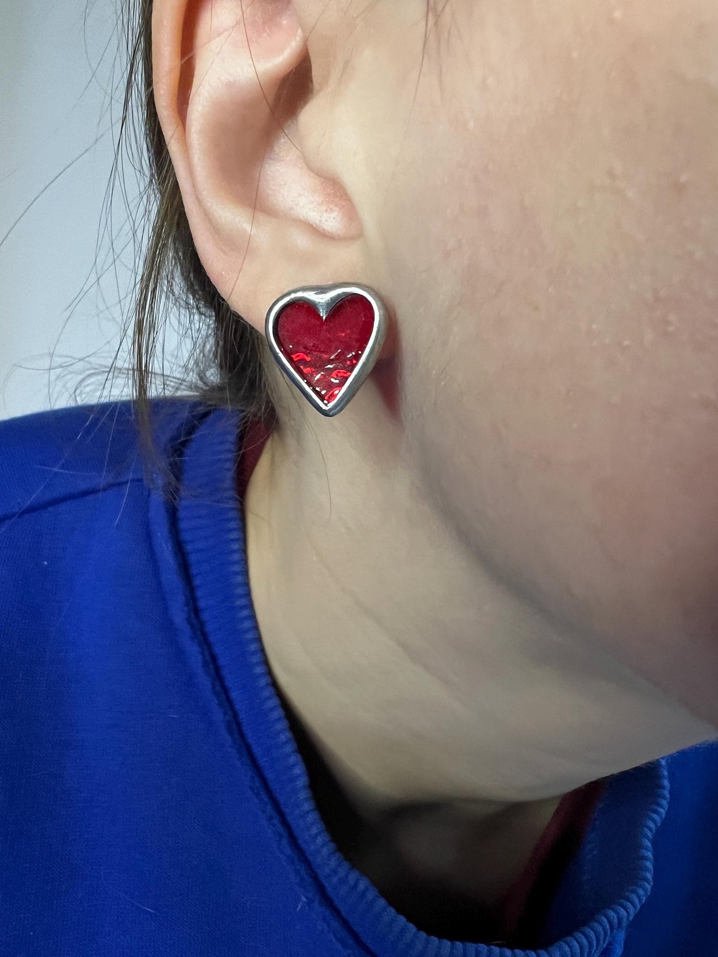 Red stained glass heart earrings on a model's ear