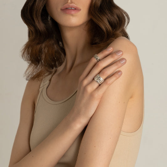 Model wearing two silver rings on shoulder – geometric brutalist jewelry set