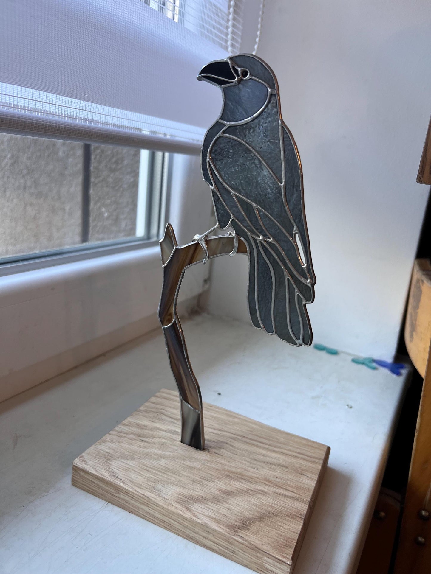 Stained glass crow statue near window – dark elegant home accent