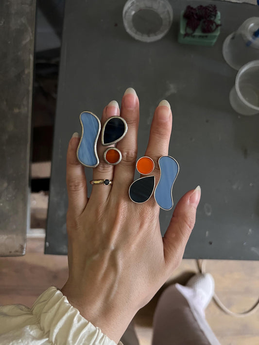 Handmade modern glass ring with blue, black, and orange glass inserts on silver base — abstract statement jewelry