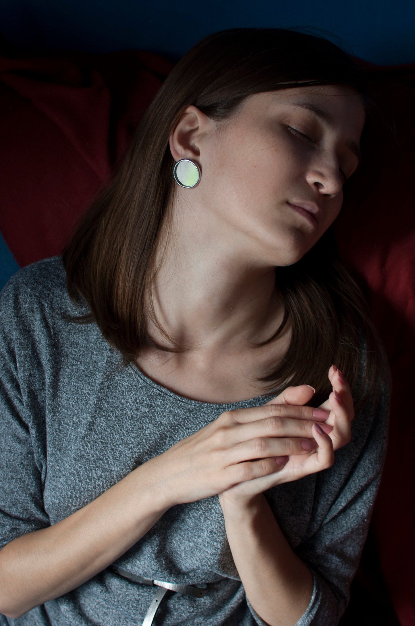 Geometric round earrings made of handmade mirrored glass on the model's ear