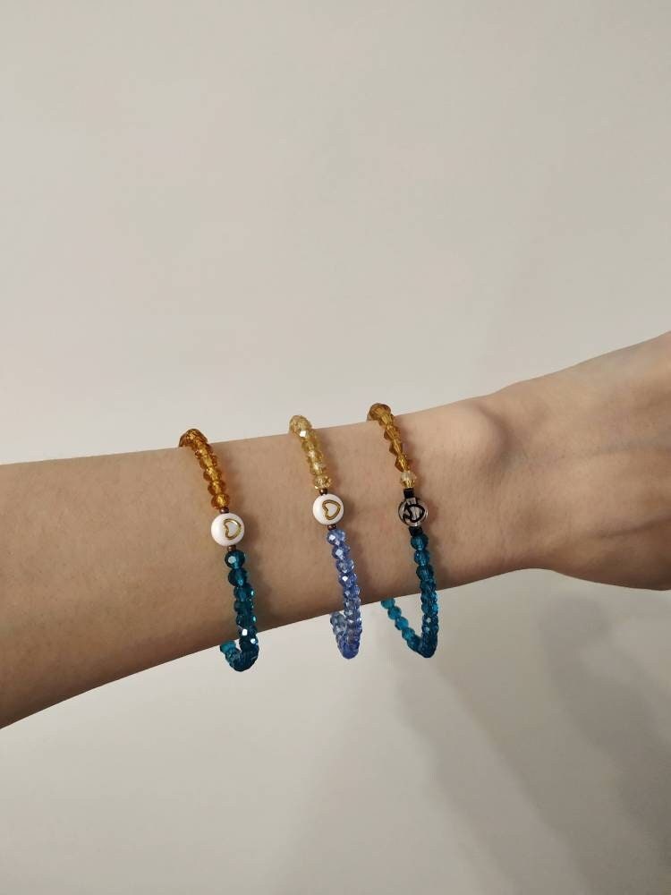 Blue and yellow glass bead bracelet on wrist, handmade elastic jewelry