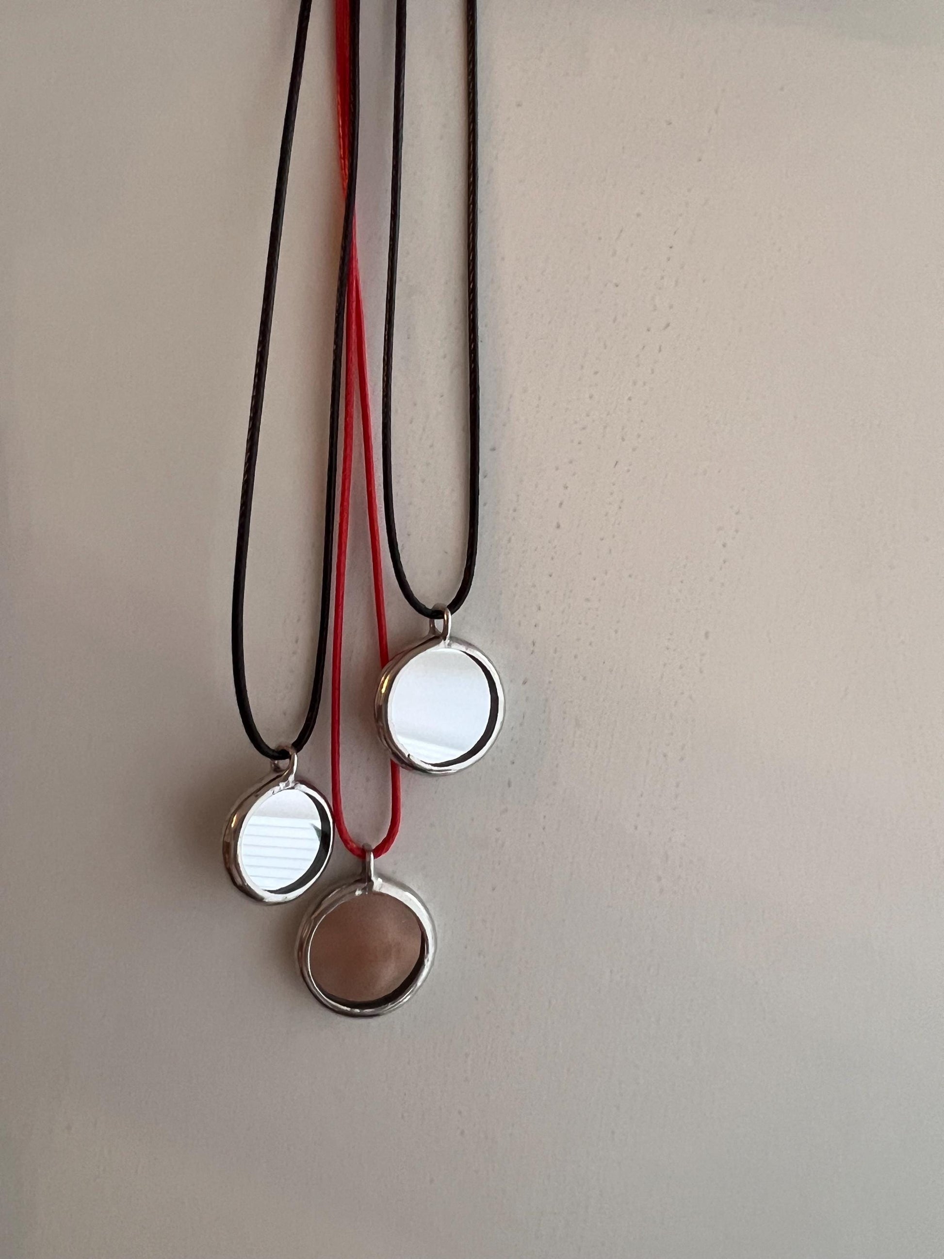 Hanging round mirror pendants on cords