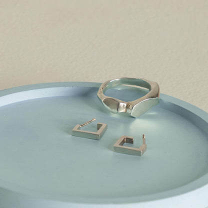 Handmade unisex silver jewelry in minimalist artistic composition.