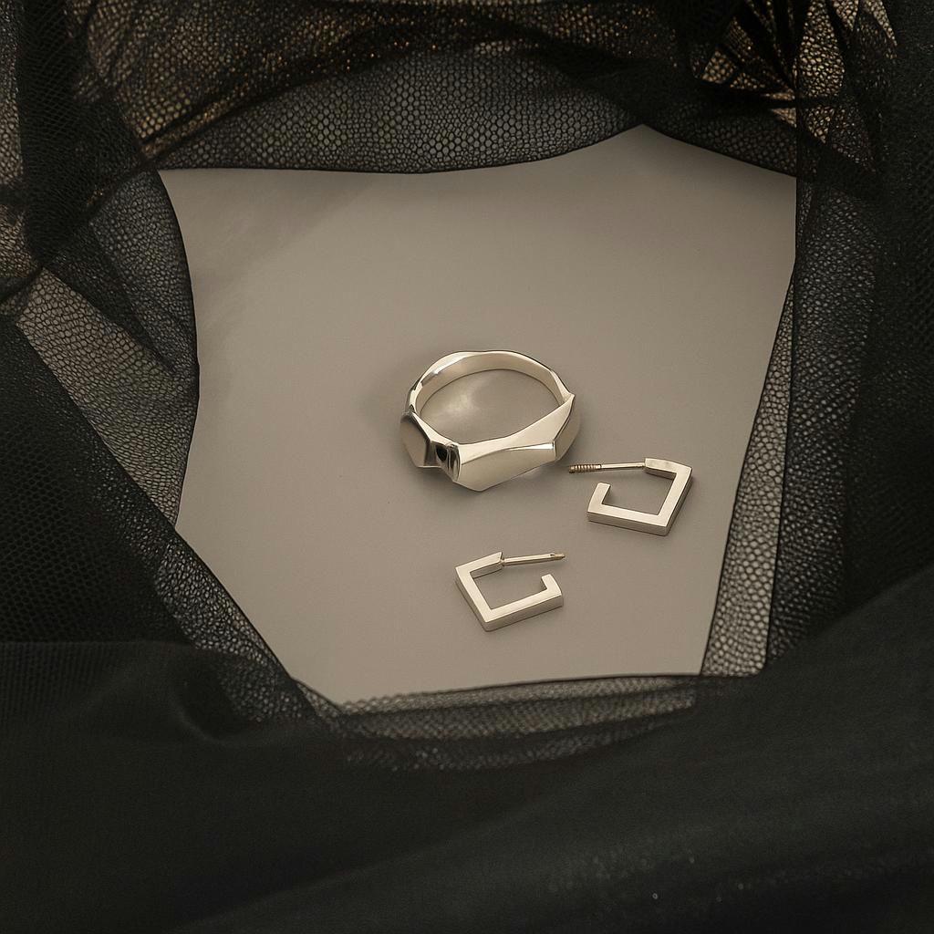 sculptural silver stud earrings on black fabric