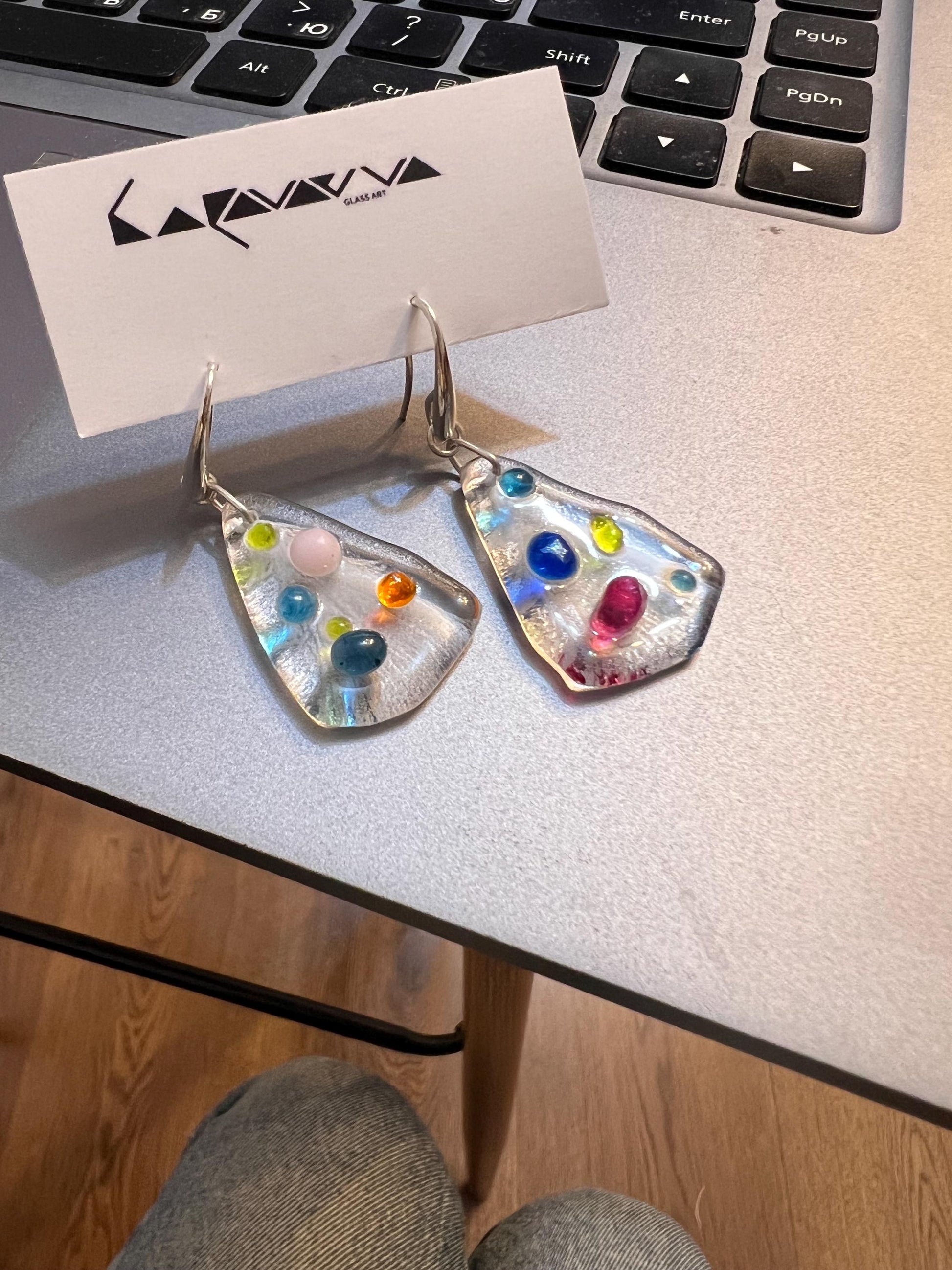 Earrings shown near window light highlighting glass transparency