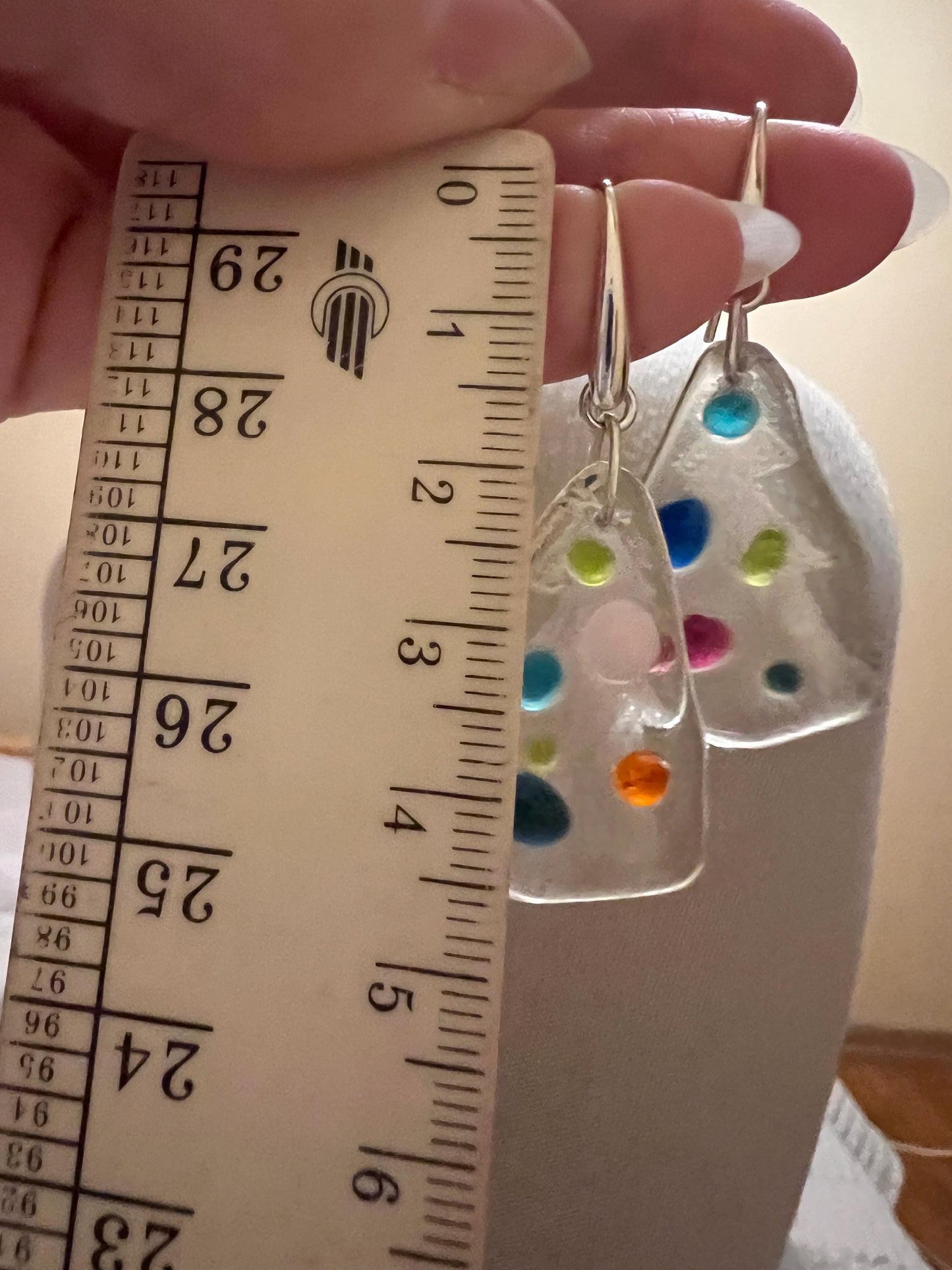 Size reference with ruler next to fused glass tree earrings