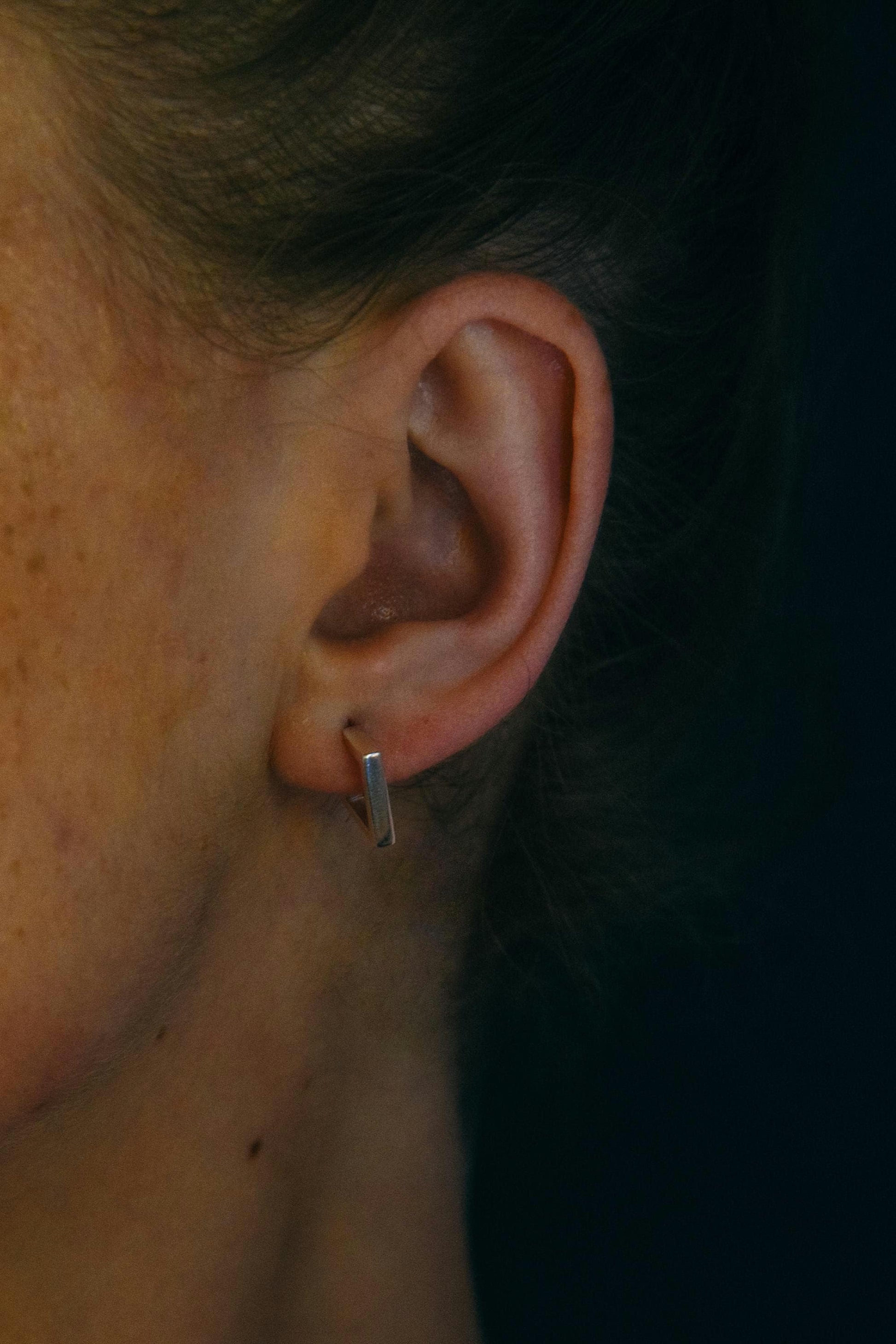 Geometric sterling silver stud worn on ear