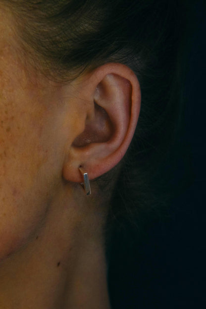 Geometric sterling silver stud worn on ear